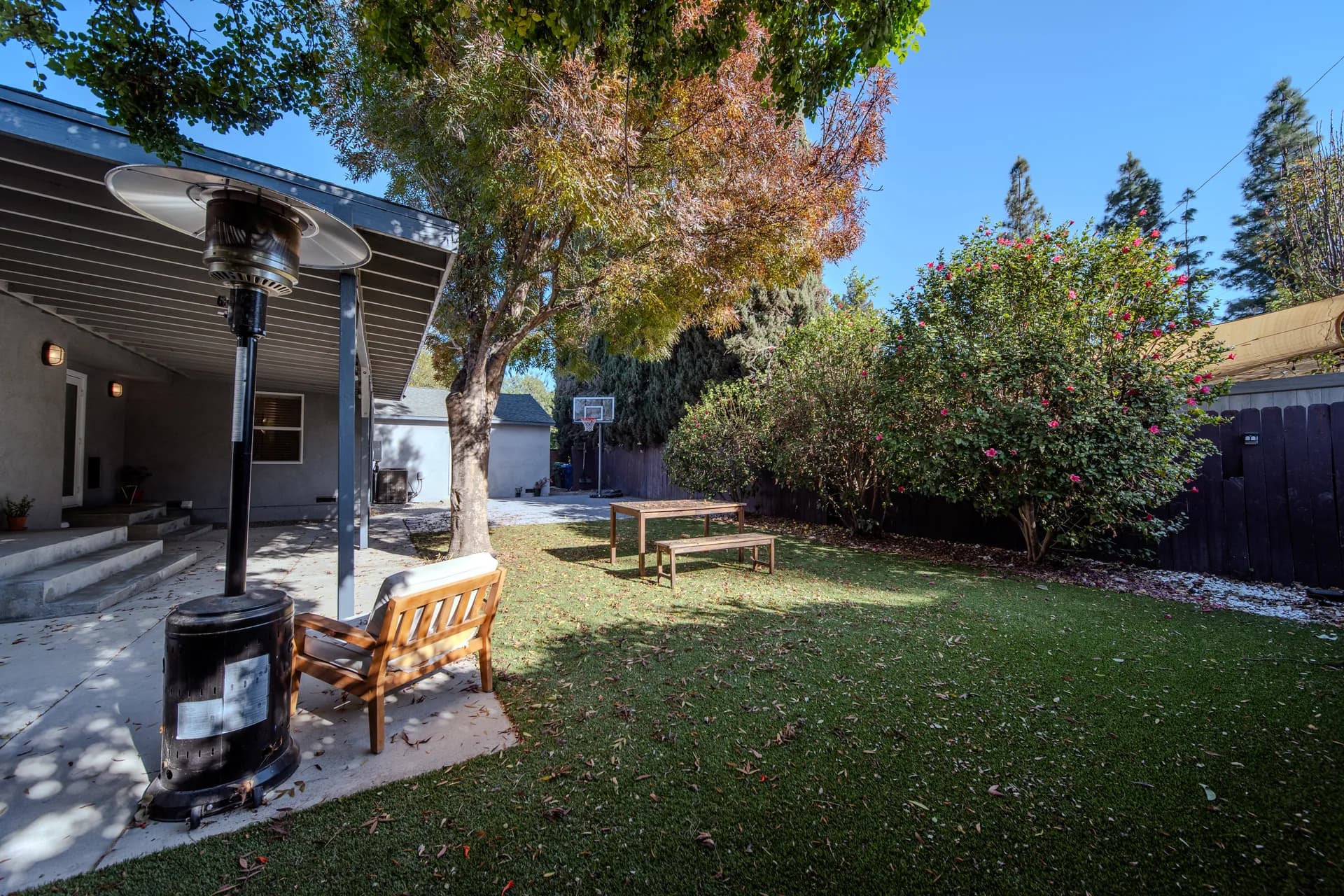 Garden lawn, shaded seating, and a mature tree
