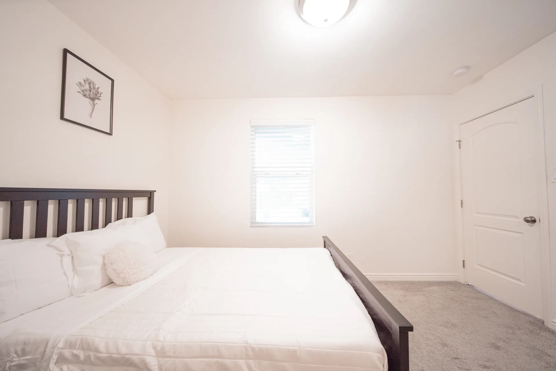 Bright bedroom with white bedding and fitted wardrobe